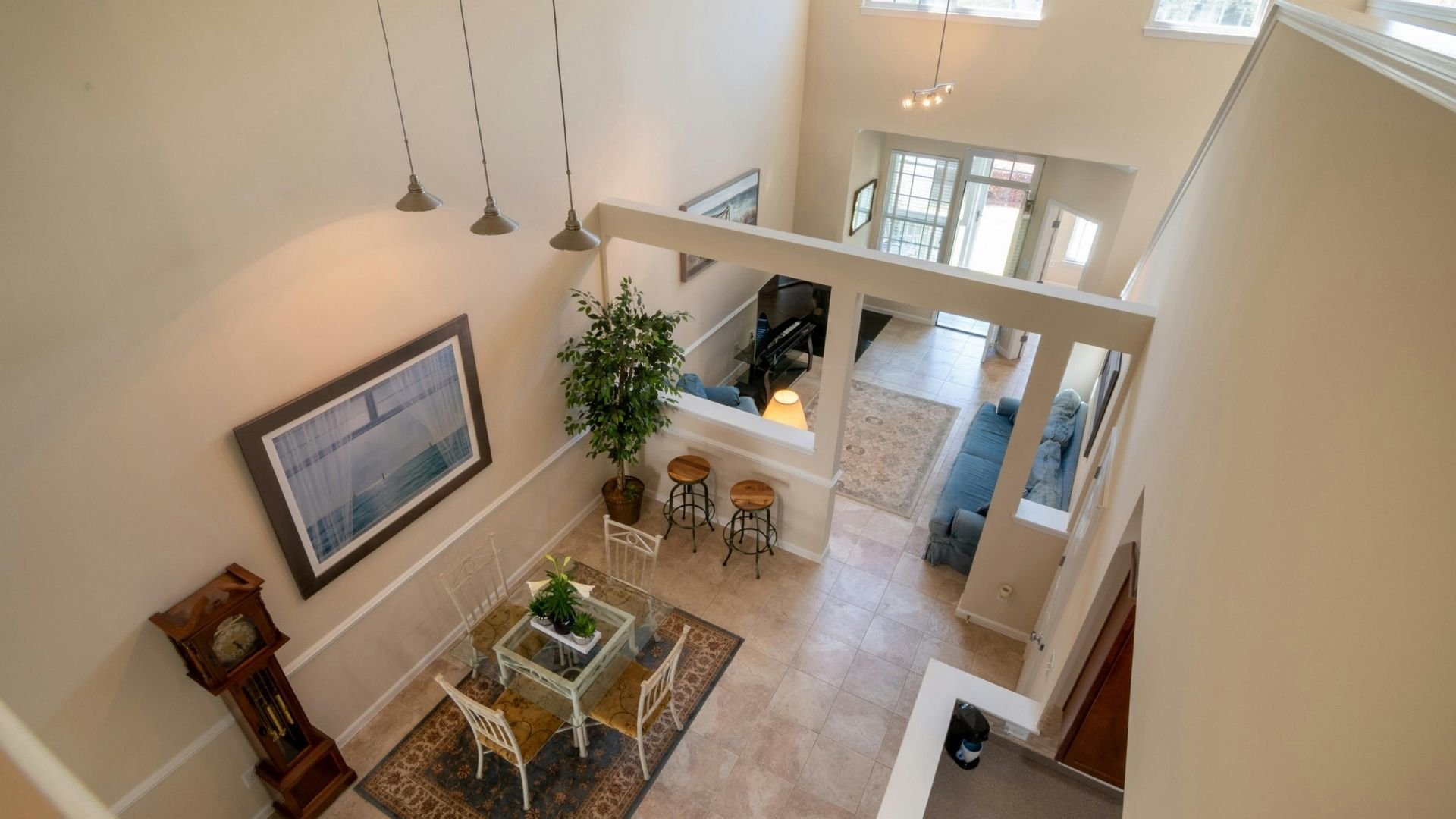 Modern open-concept home interior with high ceilings, pendant lights, and loft space.